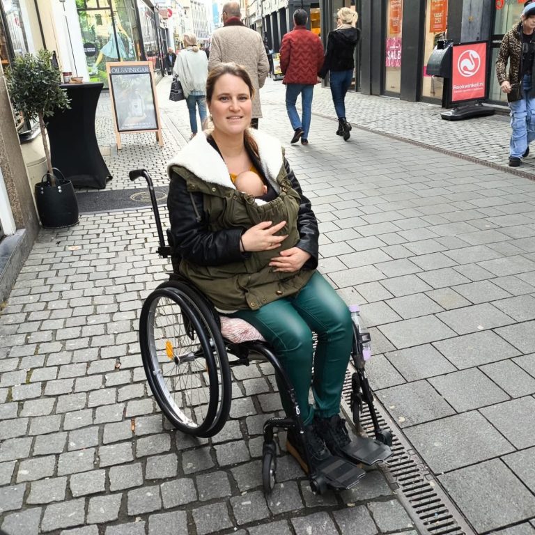 Ieder heeft zijn eigen verhaal. Op de foto zie je Cindy in haar rolstoel met haar kindje.