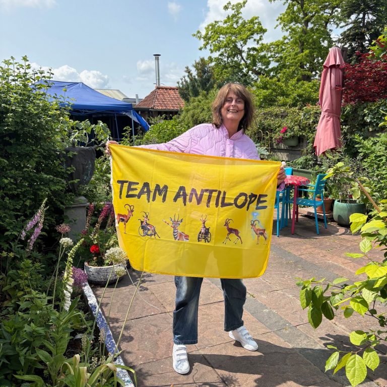 Pien staat in de tuin met de gele Team Antilope-vlag